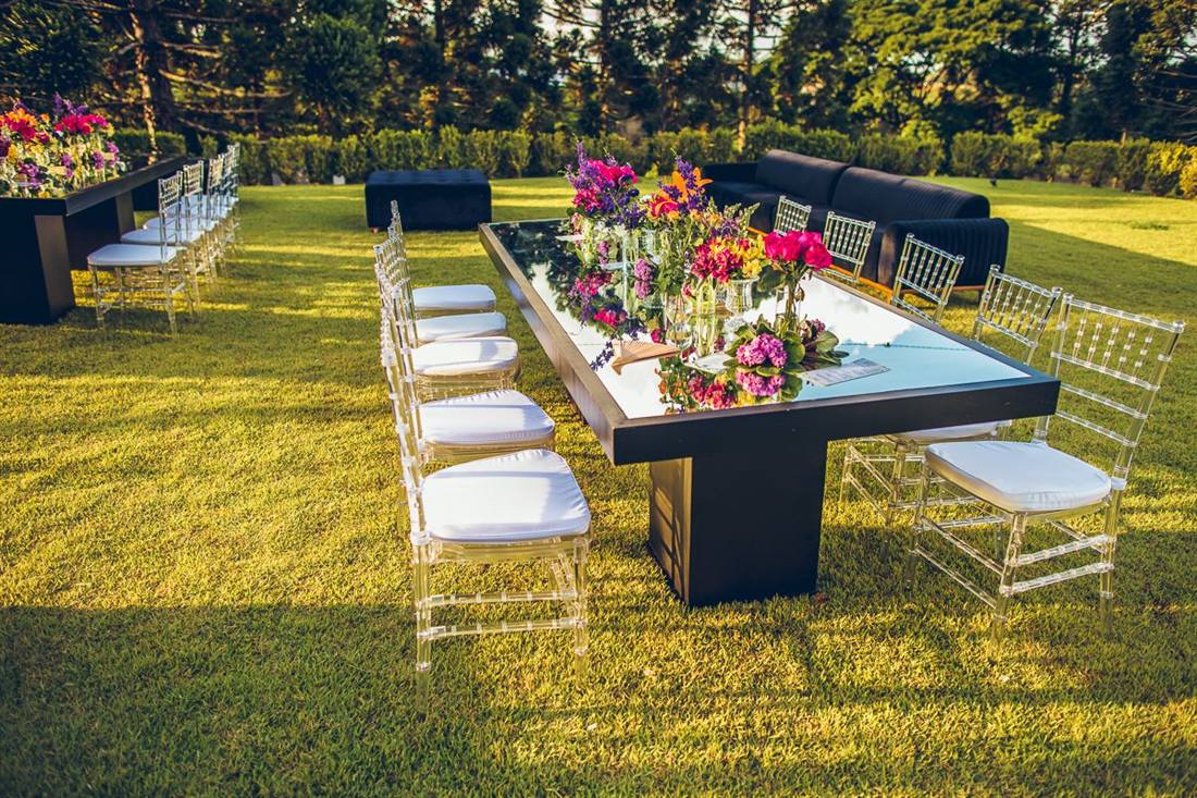 Mesa posta com flores no gramado para festa ao ar livre